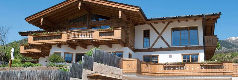 Traditionelles Holzhaus in Piesendorf mit Balkon und rustikaler Gestaltung.