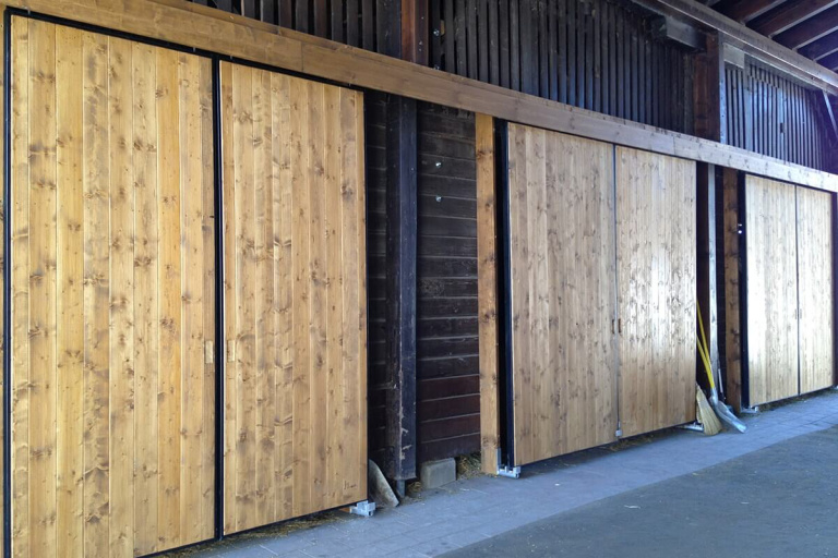 Holzschiebetüren aus Lärchenholz in einem modernen Holzbau in Piesendorf.