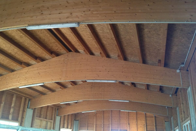 Dachkonstruktion aus Holz mit geschwungenen Sparren in einem modernen Bauprojekt.