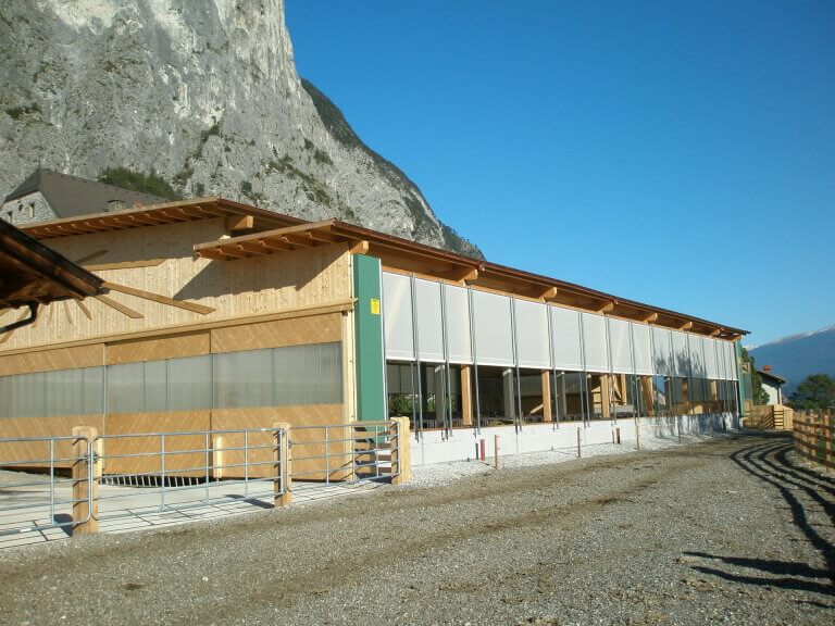 Moderne Holzbaukonstruktion mit Glasfront, umgeben von Berglandschaft in Piesendorf.