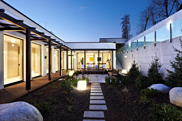 Moderne Holzarchitektur mit Garten, harmonisch in die Natur integriert. Licht und klare Linien.