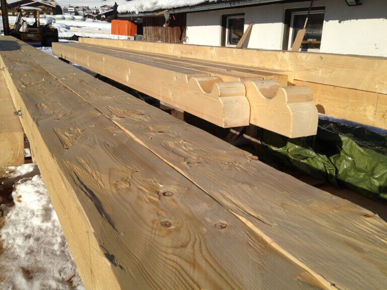 Holzbohlen und -konstruktionen auf einer Baustelle in Piesendorf im Winter.