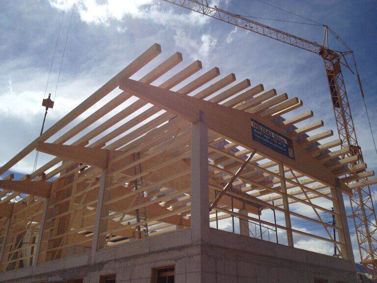Holzkonstruktion eines Gebäudes im Bau mit crane im Pinzgau, Holzbau Gläser.