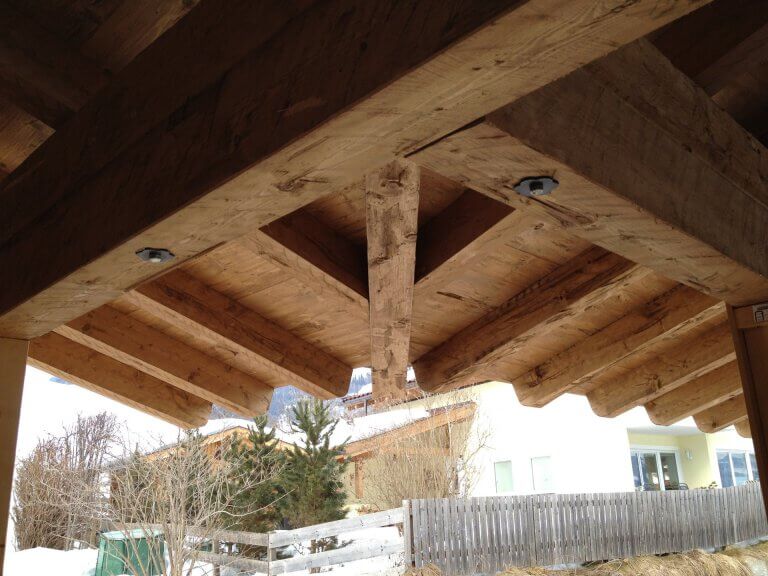 Ansicht der Holzstrukturen eines Daches im Bau, mit natürlicher Umgebung in Piesendorf.