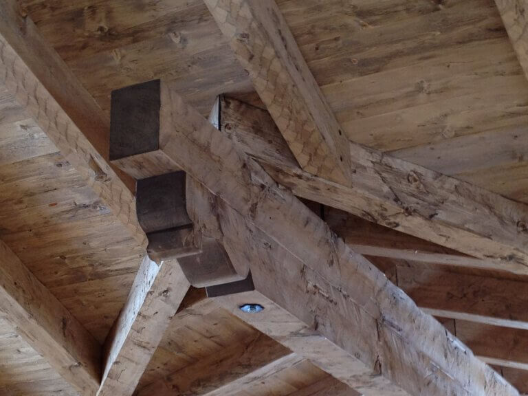 Holzbau mit naturbelassenen Balken und stabiler Konstruktion im Innenraum.