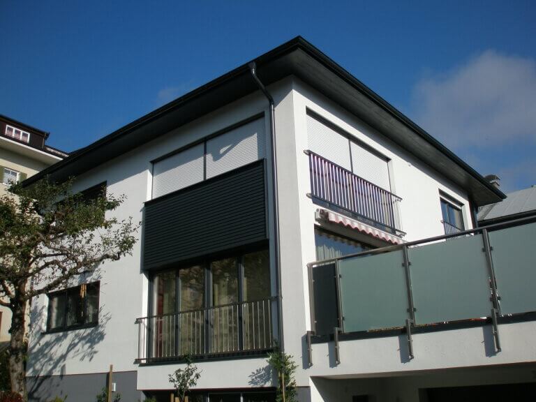 Moderne Wohnhausfassade mit Balkon und Garten, Bauweise in Piesendorf, Pinzgau.