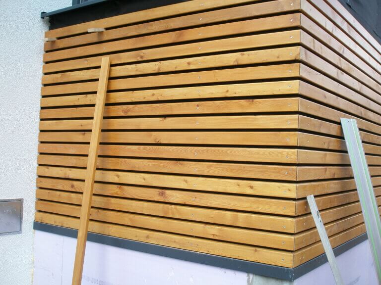 Moderne Holzkonstruktion mit horizontalen Dielen, Teil eines Bauprojekts in Piesendorf.